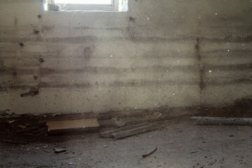 Sunlight filters through a cracked window, illuminating floating dust in a neglected room. The sparse, dusty scene evokes a sense of abandonment and forgotten memories.