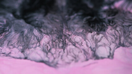 Paint wave. Ink spill. Defocused pink glitter texture. Shining black emulsion mix flow mystical hypnotical abstract fluid background.