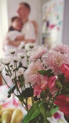 Romantic married couple dancing at home near the window against a background of flowers