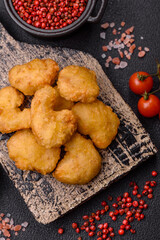 Delicious fresh crispy chicken nuggets on a dark concrete background