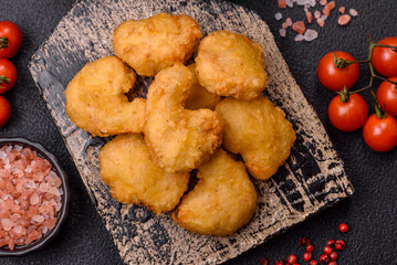 Delicious fresh crispy chicken nuggets on a dark concrete background