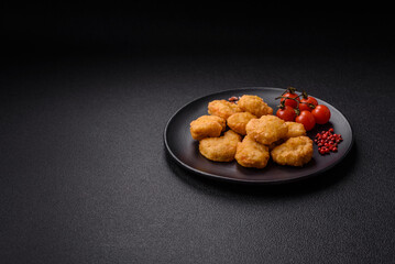Delicious fresh crispy chicken nuggets on a dark concrete background