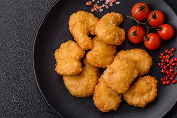 Delicious fresh crispy chicken nuggets on a dark concrete background