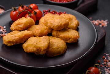 Delicious fresh crispy chicken nuggets on a dark concrete background