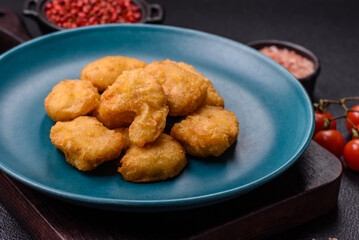 Delicious fresh crispy chicken nuggets on a dark concrete background