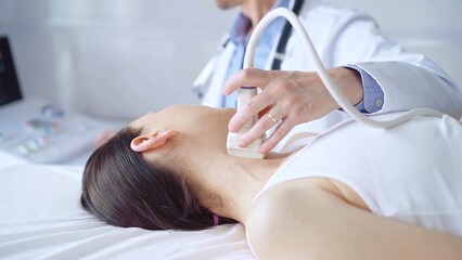 Fototapeta premium Doctor man is using ultrasound equipment on neck of female patient lying down for a medical examination. Medicine and science
