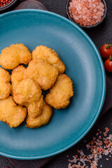 Delicious fresh crispy chicken nuggets on a dark concrete background