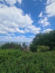 grüne Landschaft mit einem schönen, blauen Wolkenhimmel und Blick auf die Ostsee in Wilhelmshagen, Mecklenburg - Vorpommern