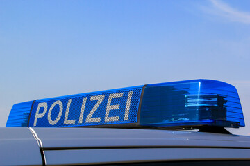 Die Rundumleuchte eines Polizeiwagens auf dem Dach des Autos.
