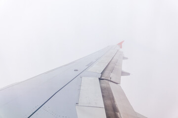 View from the airplane window at a beautiful cloudy sky and the airplane wing