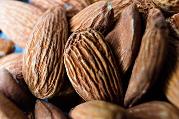 Close up photo of some almonds in a bowl on a table.