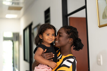 Happy Young Black Mother Holding Her 2-Year-Old Daughter at Home