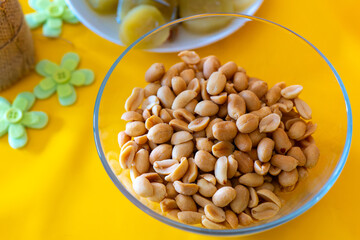 bowl of peanuts is on a yellow table