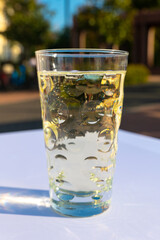glass of water with a blue rim sits on a table