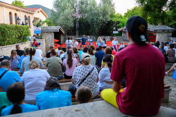 Pilgrims praying and lighting candles at the Cross near the Saint James Church in Medjugorje.