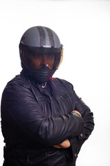 Biker, an adult man in black biker clothing and helmet in front of a white background, selective focus.