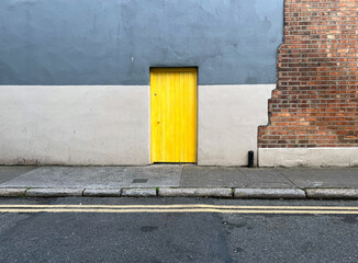 Yellow door on urban street walls in Dublin