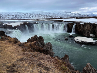 Godafoss waterfall with snowy mountains