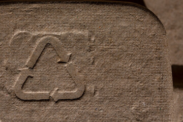 Recycling Symbol on Cardboard Texture. Close-up of a recycling symbol embossed on a rough cardboard...