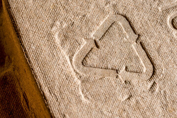 Close-up of embossed recycling symbol on cardboard. Close-up shot of an embossed recycling symbol...