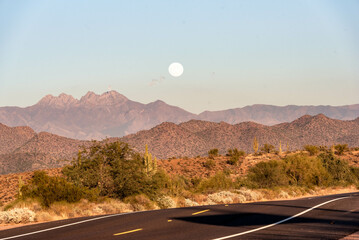 full moon rising over desert mountains