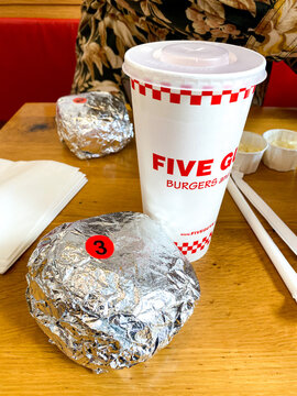 A burger and soda drink at a Five Guys restaurant