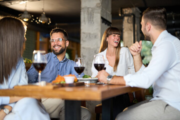 Happy business colleagues talking on a lunch in a restaurant
