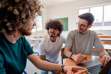 A group of happy diverse college students studying together in the classroom.