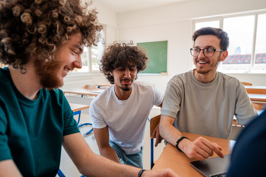 A group of happy diverse college students studying together in the classroom. - Powered by Adobe