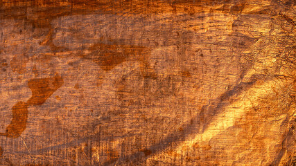 Golden light illuminating a rough textured surface in the background