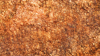 Abstract textured background created by reflected light on crumpled copper foil surface