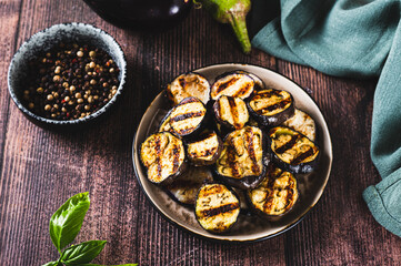 Delicious pieces of grilled eggplant on a plate on the table