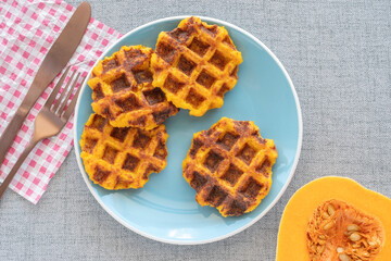 Pumpkin waffles on blue plate for tasty healthy snack.