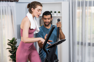 Fototapeta premium Athletic and sporty young couple or fitness buddy running on running machine together, home body workout exercise session as healthy sport lifestyle at home. Gaiety home exercise workout training.