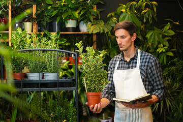 A male worker checking out flowers in a flower shop and writing them down