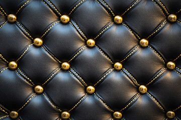 Obraz premium Luxurious black quilted leather upholstery with gold buttons, showcasing a classic and sophisticated texture