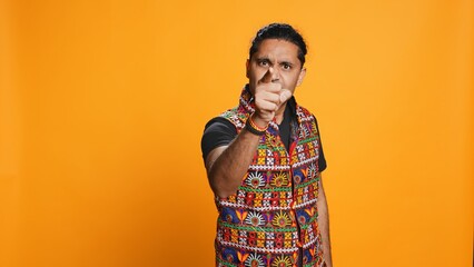 Disappointed indian man admonishing friend over debacle, isolated over studio background. Upset...