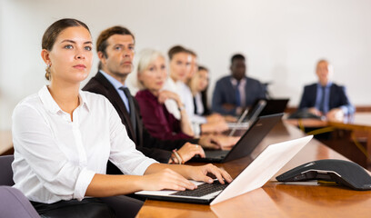 Fototapeta premium Focused portrait of business woman using laptop at business meeting