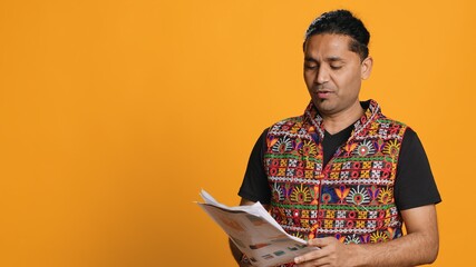Indian man browsing though financial audit report files, throwing them in anger, feeling...
