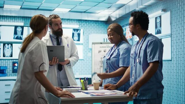 Neuroscience expert reviewing mri brain scan results with doctors, discussing the right treatment plan for disease prevention. Licensed neurologist and his staff examine tomography. Camera B.