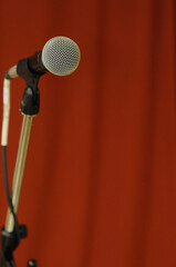 Microphone in front of red curtain.