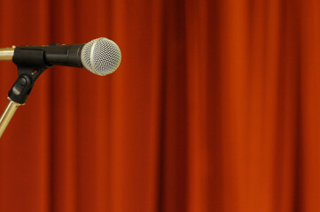 Microphone in front of red curtain.