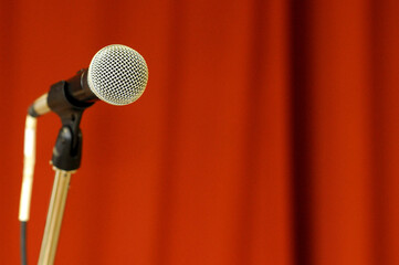 Microphone in front of red curtain.