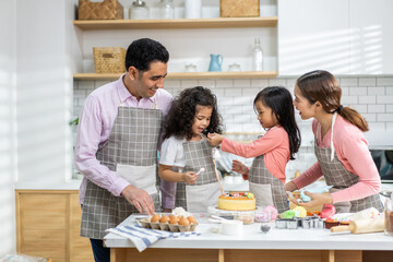 Portrait of enjoy happy love asian family father and mother with little asian girl daughter child play and having fun cooking food together with baking cookie and cake ingredient in kitchen