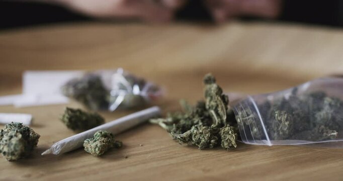 Marijuana bud, joint and weed blunt, 420 cannabis leaf or CBD hemp package for smoking, drug use habit or cigarette. Herbal wellness, closeup and wooden desk of pot, indica hash or THC product