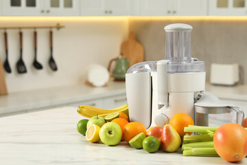 Modern juicer and fruits on white marble table, space for text