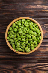 Raw green edamame soybeans on wooden table, top view