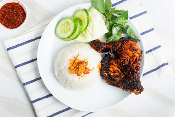 Grilled chicken served with rice, sliced ​​cucumber, cabbage and basil leaves. Served with chili sauce. Perfect for recipe, article, catalogue, commercial, or any cooking content.