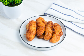 Fried Banana served on a white plate. Indonesian food. Indonesian street food. Perfect for recipe, article, catalogue, commercial, or any cooking contents.