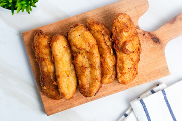 Fried Banana served on a wooden cutting board. Indonesian street food. Indonesian food. Perfect for recipe, article, catalogue, commercial, or any cooking contents.